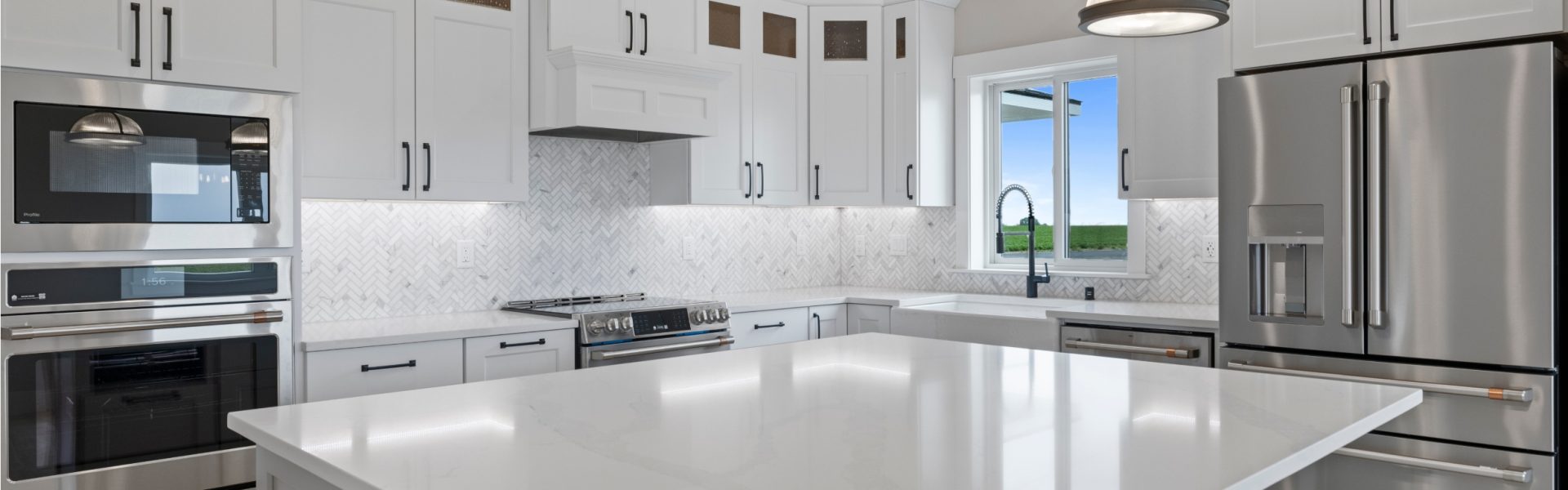Kitchen view with white countertops and GE Cafe appliances