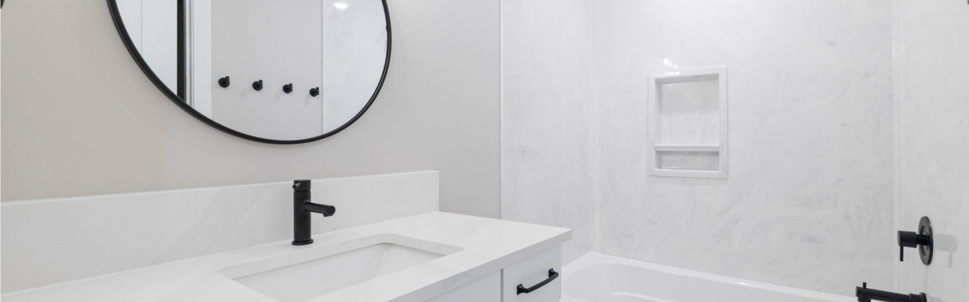 Modern bathroom with circle mirror and white cabinets